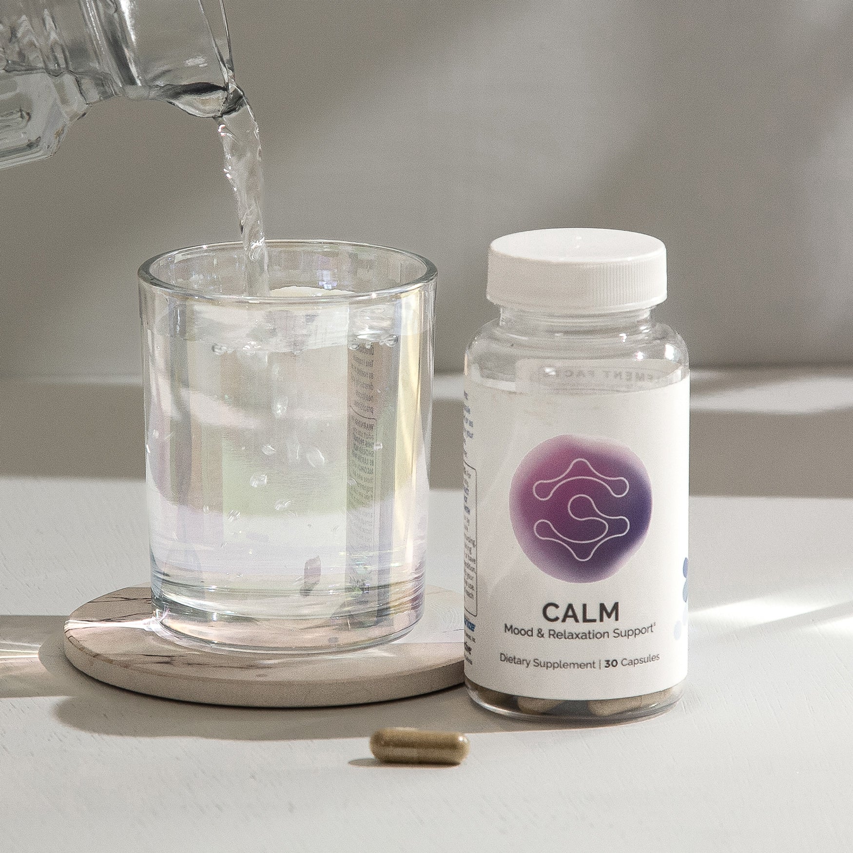 Mood & relaxation supplement bottle with 30 capsules, next to a glass of water.