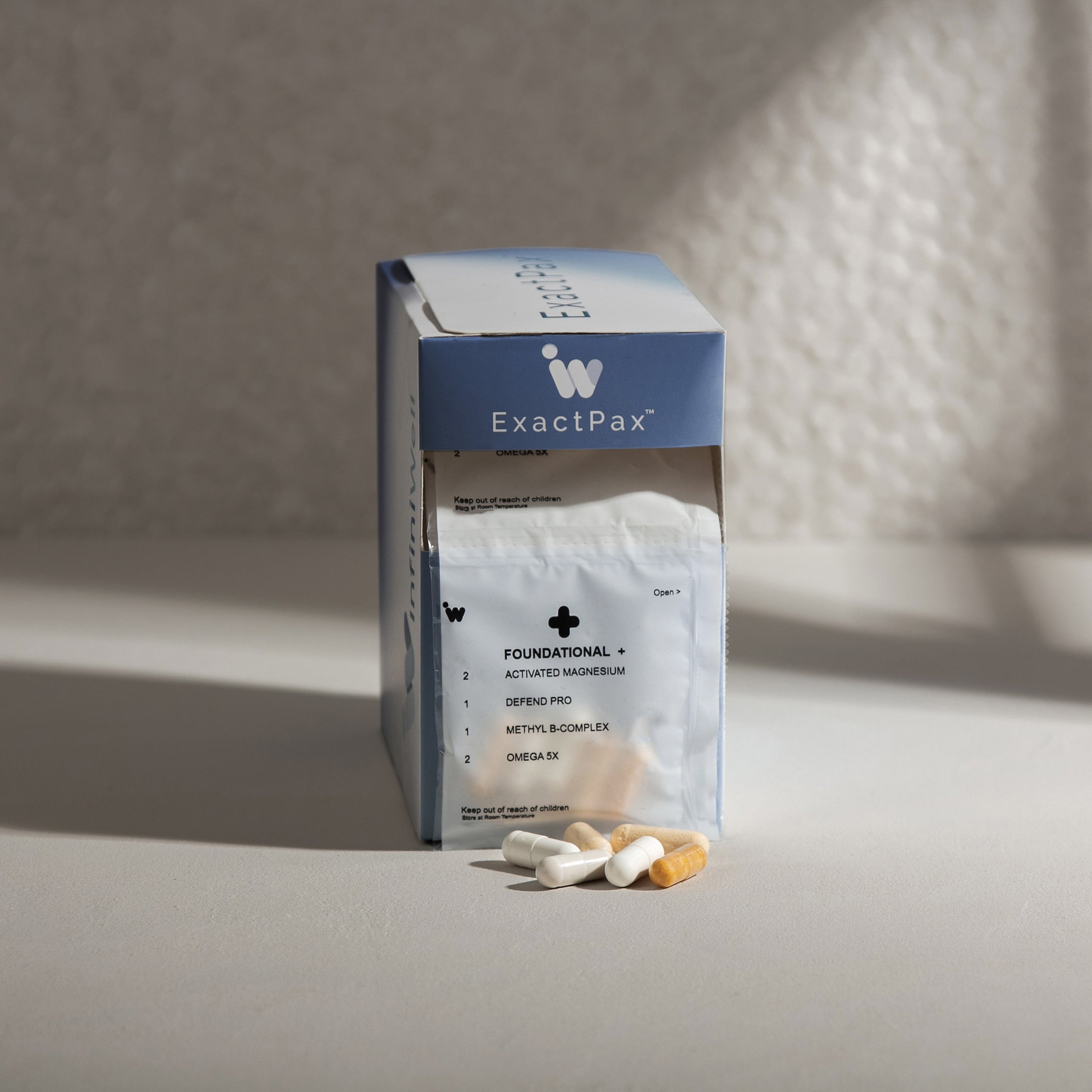 Supplement box and capsules;  various shades of white and beige against a neutral background.