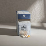 Supplement box and capsules; various shades of white and beige against a neutral background.