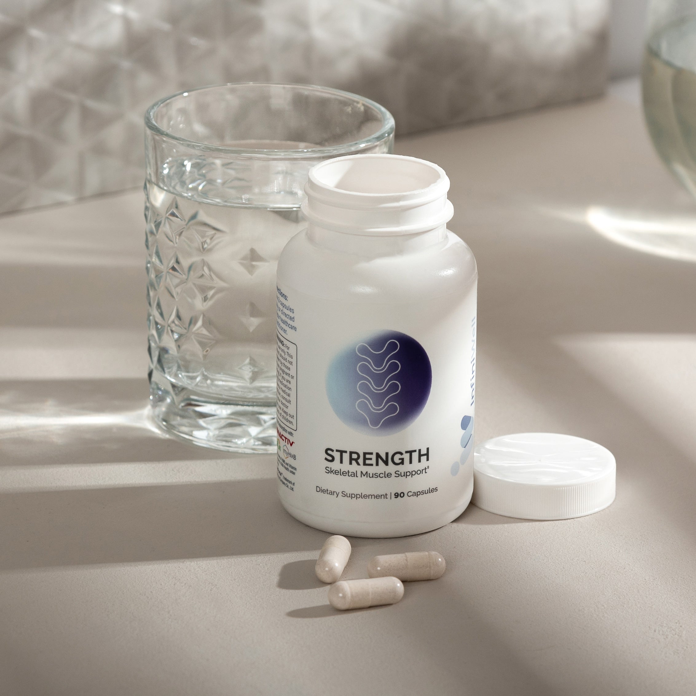 Skeletal muscle support supplement bottle, 90 capsules, with pills and water glass.
