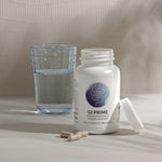 InfiniWell GI PRIME dietary supplement bottle with capsules beside a glass of water, 90 capsules.