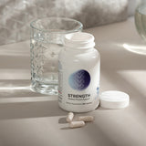Skeletal muscle support supplement bottle, 90 capsules, with pills and water glass.
